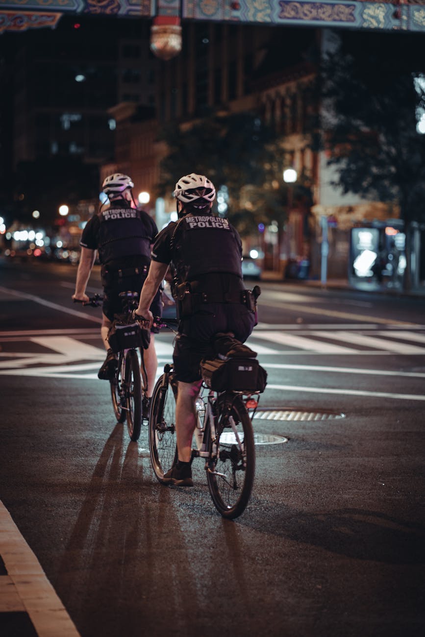 policemen riding on bicycles on street at night time