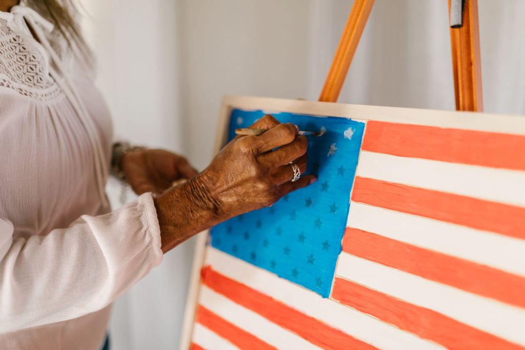 person painting an american flag using watercolor