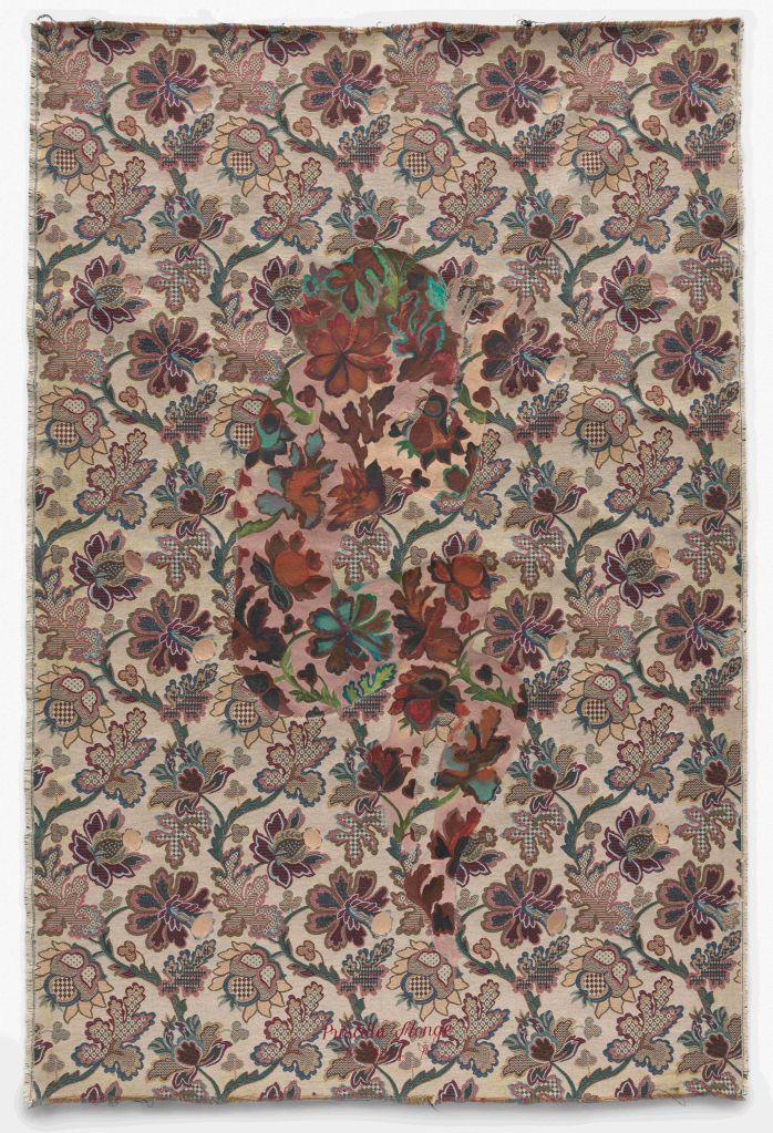 A detailed floral textile pattern with intricate, overlapping designs in shades of brown, red, green, and blue.