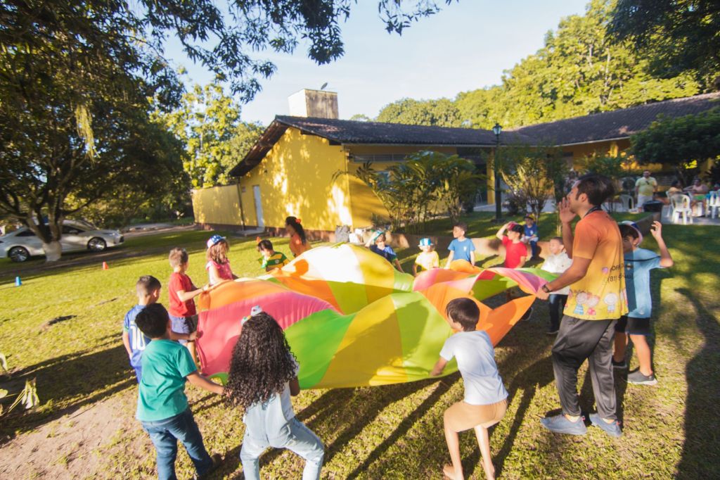 children playing with a colorful parachute in the yard