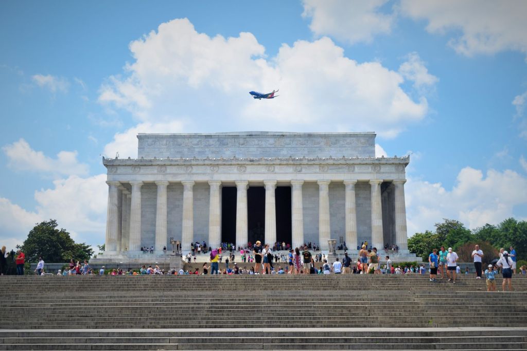 people walking in front of lincoln memorial under the blue sky and white clouds