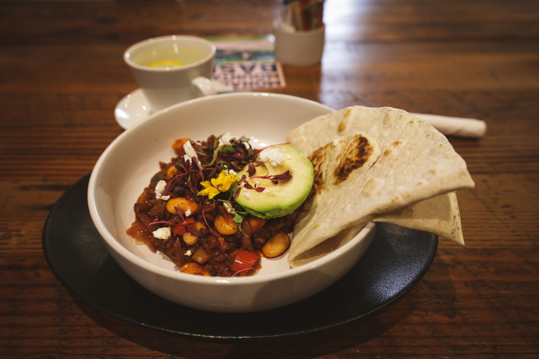 hearty mexican chili with tortilla and avocado